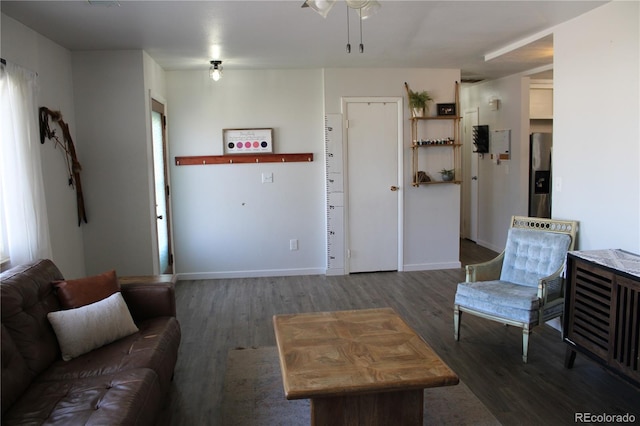 living room featuring dark wood-type flooring, ceiling fan, and a healthy amount of sunlight