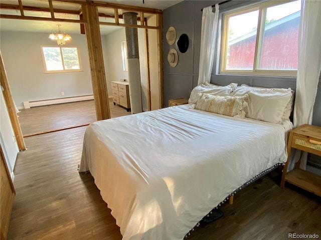 bedroom featuring a baseboard radiator, an inviting chandelier, hardwood / wood-style floors, and a closet