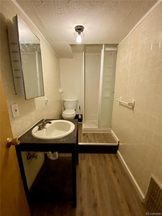 bathroom with toilet, hardwood / wood-style flooring, sink, and a textured ceiling