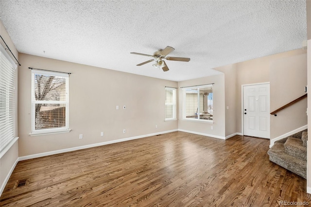 unfurnished living room with hardwood / wood-style floors, a textured ceiling, plenty of natural light, and ceiling fan