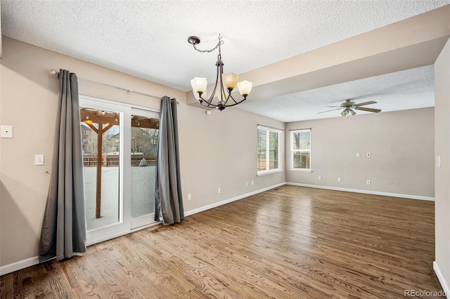 spare room with hardwood / wood-style flooring, ceiling fan with notable chandelier, and a textured ceiling