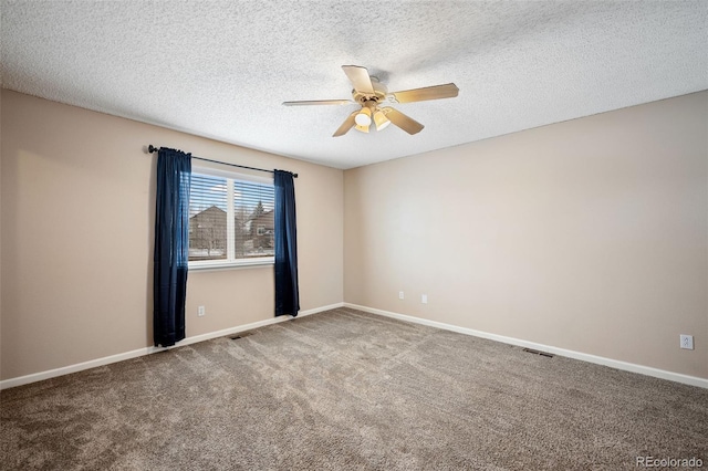 carpeted spare room featuring ceiling fan and a textured ceiling