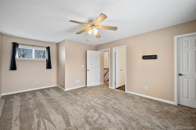 unfurnished bedroom featuring ceiling fan, carpet, and a textured ceiling