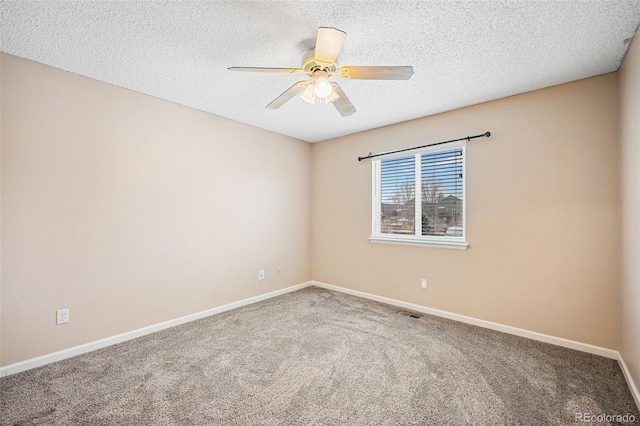 empty room with ceiling fan, carpet, and a textured ceiling