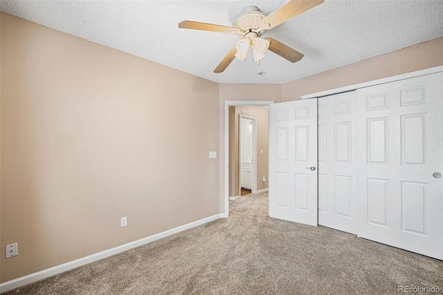 unfurnished bedroom featuring ceiling fan, a closet, carpet floors, and a textured ceiling