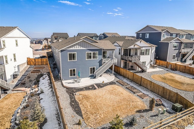 rear view of house with a patio, stairway, a fenced backyard, and a residential view