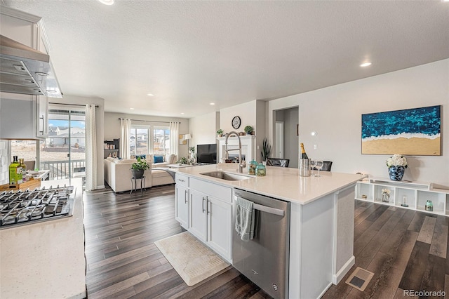 kitchen featuring visible vents, a sink, open floor plan, dark wood-style flooring, and stainless steel appliances
