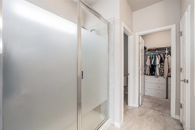 full bathroom with toilet, a stall shower, and a walk in closet