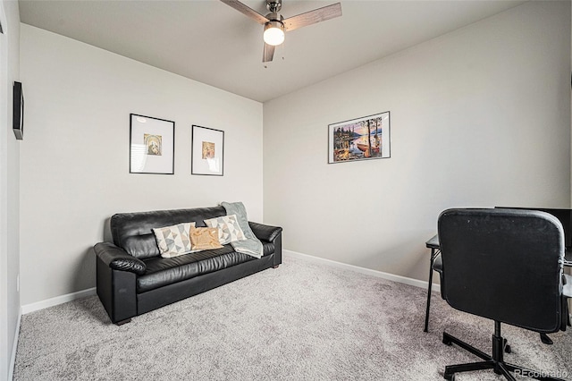 carpeted office space featuring ceiling fan and baseboards