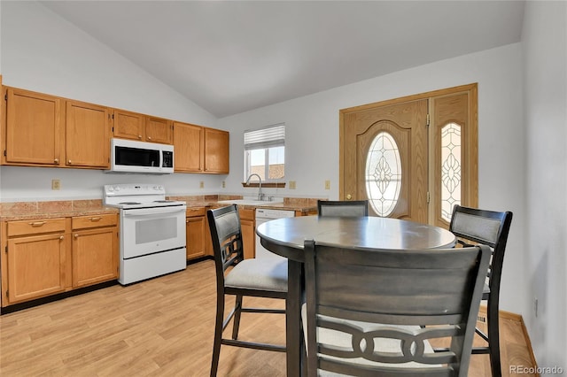 5056 E 112th Ct, Thornton, CO 80233 - kitchen with white appliances, vaulted ceiling, light countertops, light wood finished floors, and brown cabinetry