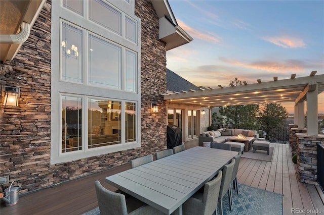 wooden terrace featuring grilling area, an outdoor living space with a fire pit, outdoor dining space, and a pergola