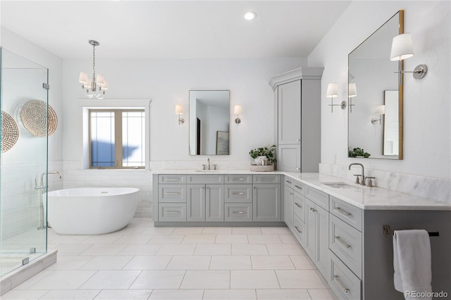 bathroom with a shower stall, a freestanding tub, double vanity, and a sink