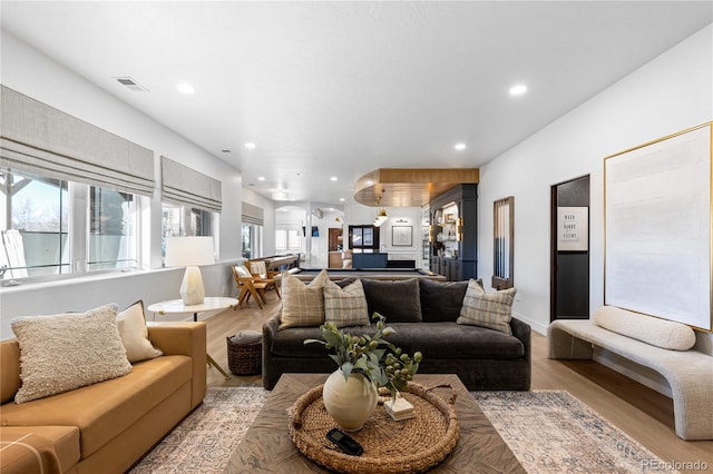 living area featuring light wood-style flooring, recessed lighting, and visible vents