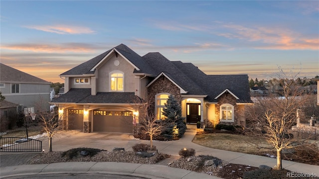 view of front of home with fence, stucco siding, concrete driveway, a garage, and stone siding