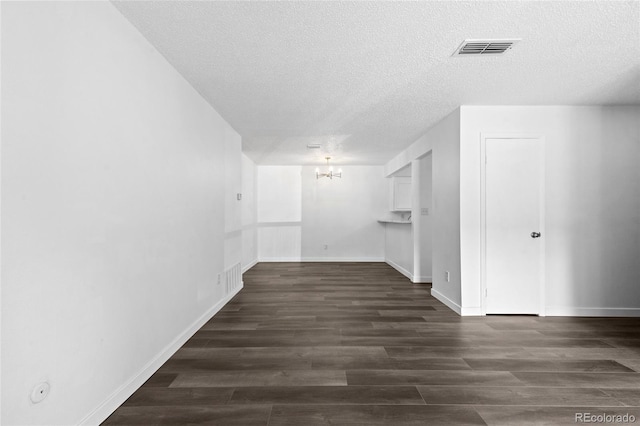7220 S Gaylord St Unit G17, Littleton, CO 80122 - spare room with a chandelier, a textured ceiling, dark wood finished floors, and baseboards