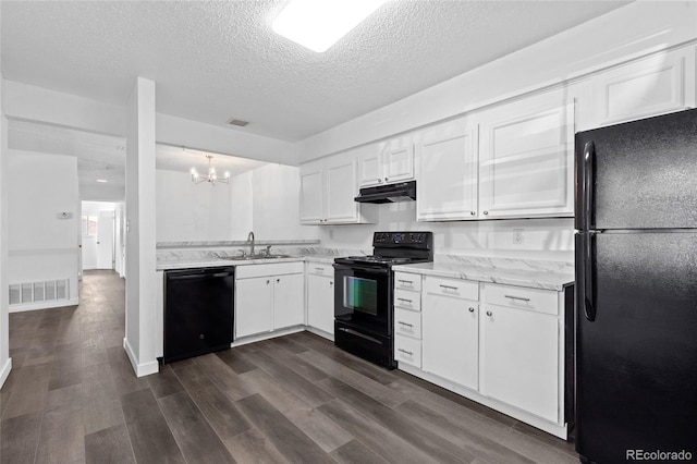 7220 S Gaylord St Unit G17, Littleton, CO 80122 - kitchen with black appliances, under cabinet range hood, a textured ceiling, a chandelier, and white cabinetry