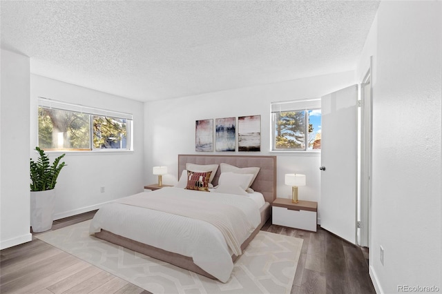 7220 S Gaylord St Unit G17, Littleton, CO 80122 - bedroom featuring wood finished floors, multiple windows, and a textured ceiling