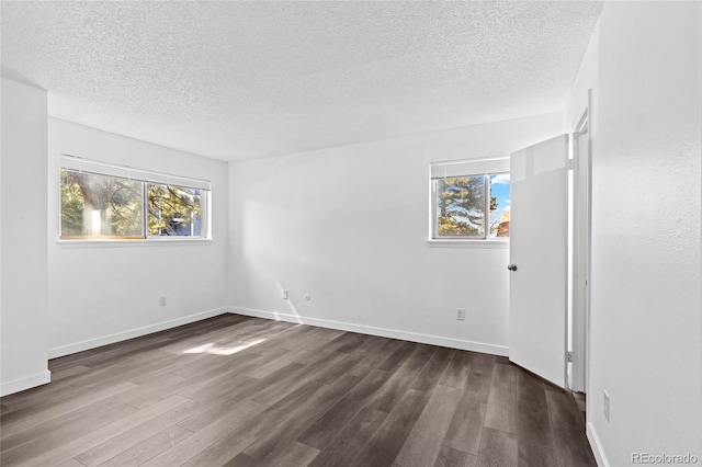 7220 S Gaylord St Unit G17, Littleton, CO 80122 - spare room featuring a textured ceiling, healthy amount of natural light, dark wood-style flooring, and baseboards