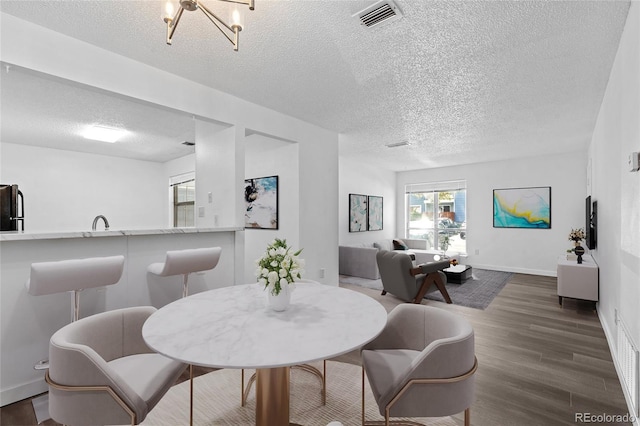 7220 S Gaylord St Unit G17, Littleton, CO 80122 - dining space featuring a textured ceiling, dark wood-style flooring, and baseboards