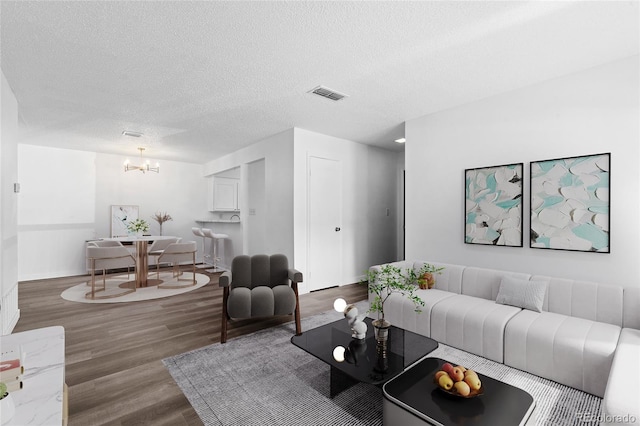 7220 S Gaylord St Unit G17, Littleton, CO 80122 - living room featuring wood finished floors, a chandelier, a textured ceiling, and baseboards