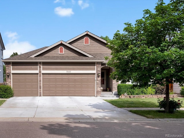 5660 S Eaton St, Littleton, CO 80123 - view of front facade featuring concrete driveway, a garage, brick siding, a front lawn, and roof with shingles