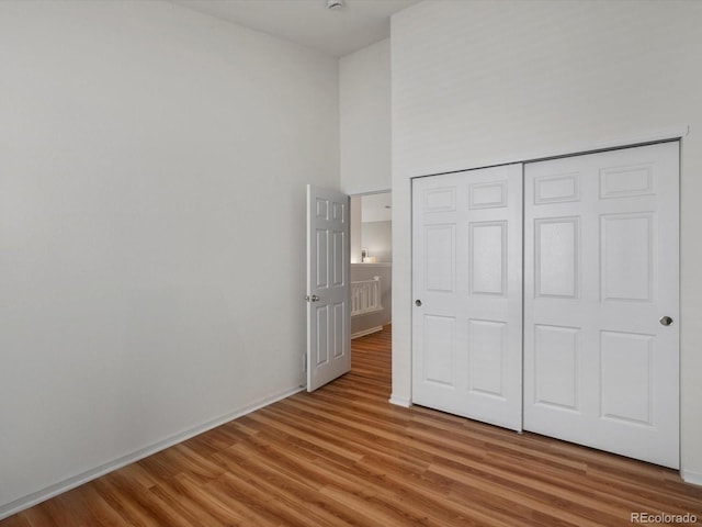 5660 S Eaton St, Littleton, CO 80123 - unfurnished bedroom with light wood-style floors, a closet, a high ceiling, and baseboards