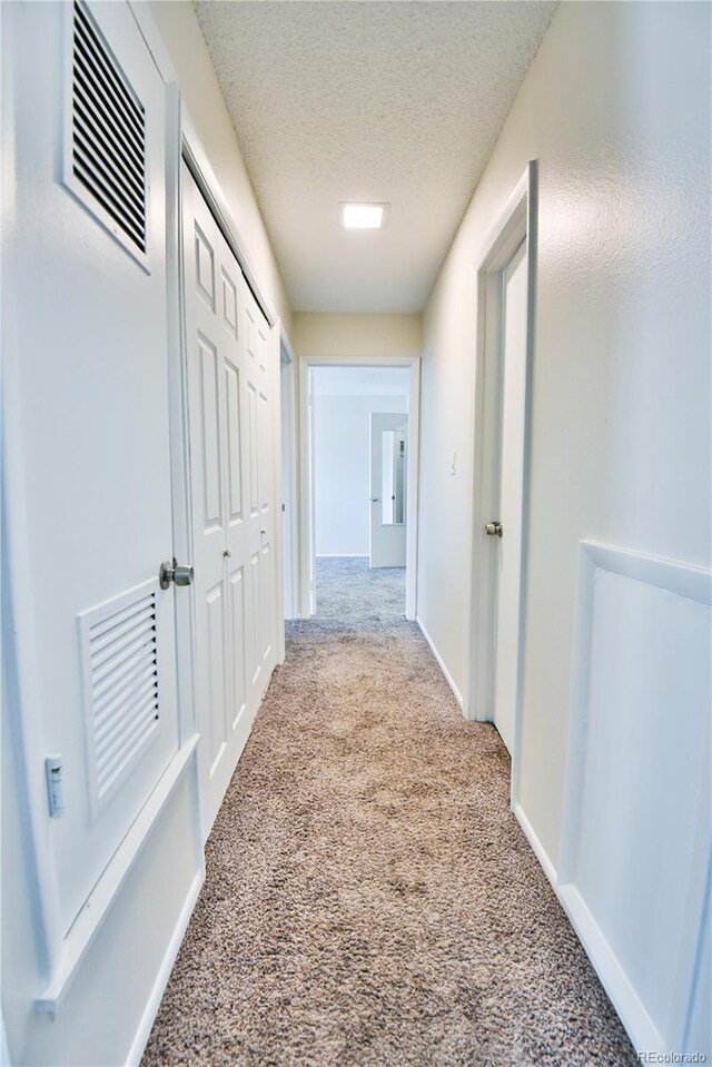 7185 S Gaylord St Unit A, Littleton, CO 80122 - hall featuring carpet floors, a textured ceiling, and baseboards