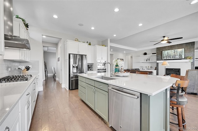 kitchen with light wood-type flooring, appliances with stainless steel finishes, light countertops, and a sink