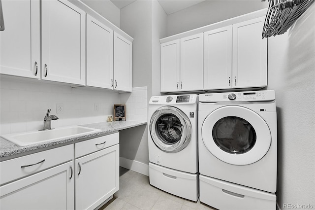 laundry area featuring washer and clothes dryer, a sink, and cabinet space