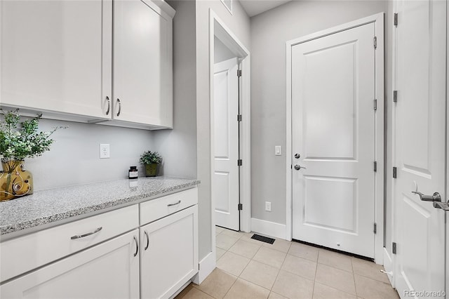 interior space with light tile patterned floors, baseboards, and visible vents