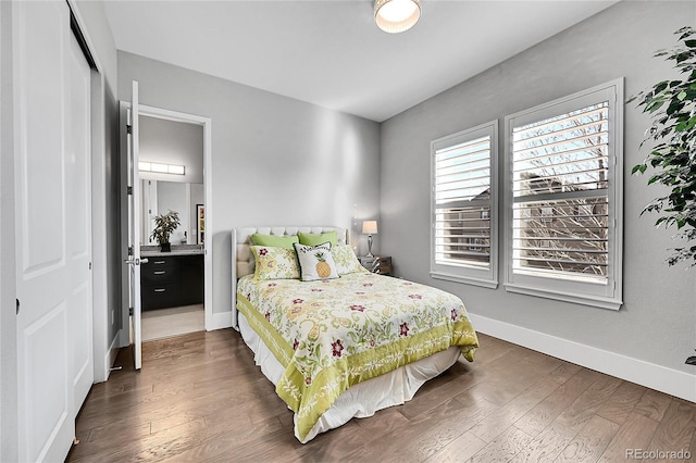 bedroom with a closet, wood-type flooring, and baseboards