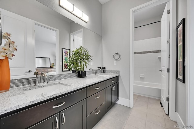 full bathroom featuring double vanity, tile patterned flooring, backsplash, and a sink