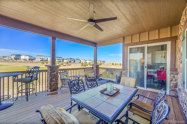 wooden terrace with ceiling fan and outdoor dining area