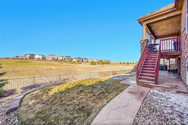 view of yard with a residential view, a patio area, fence, and stairway