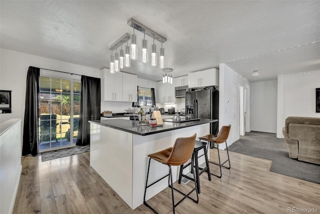 2279 S Lewiston St, Aurora, CO 80013 - kitchen featuring stainless steel microwave, open floor plan, dark countertops, light wood-style floors, and healthy amount of natural light