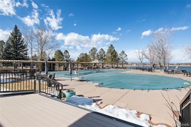 view of pool with a water view and a patio area