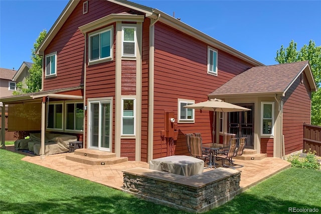 rear view of house featuring a yard and a patio area