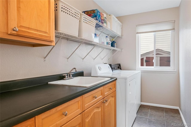 clothes washing area with cabinets, independent washer and dryer, dark tile patterned flooring, and sink