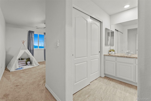 interior space featuring ceiling fan, baseboards, and vanity