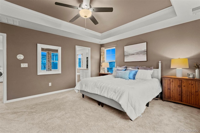 carpeted bedroom featuring ensuite bathroom, visible vents, baseboards, ornamental molding, and a raised ceiling