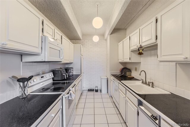 kitchen with light tile patterned flooring, sink, white cabinetry, hanging light fixtures, and white appliances