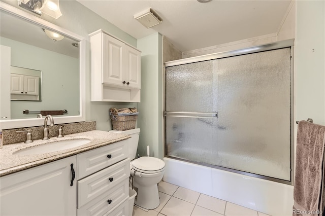 full bathroom featuring tile patterned flooring, enclosed tub / shower combo, vanity, and toilet