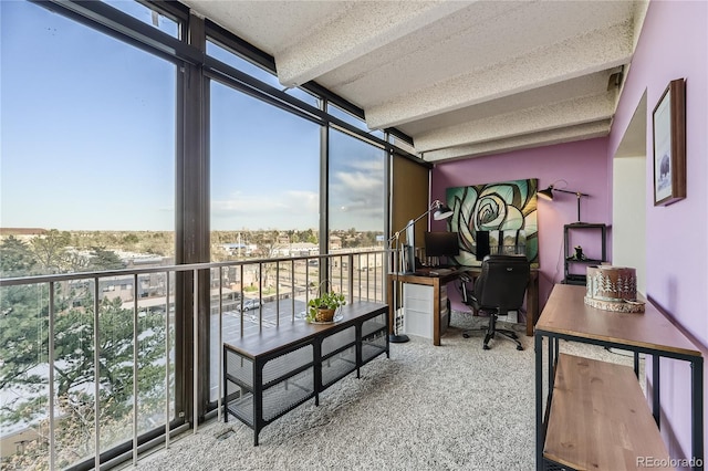 carpeted office space with a textured ceiling, floor to ceiling windows, and beamed ceiling