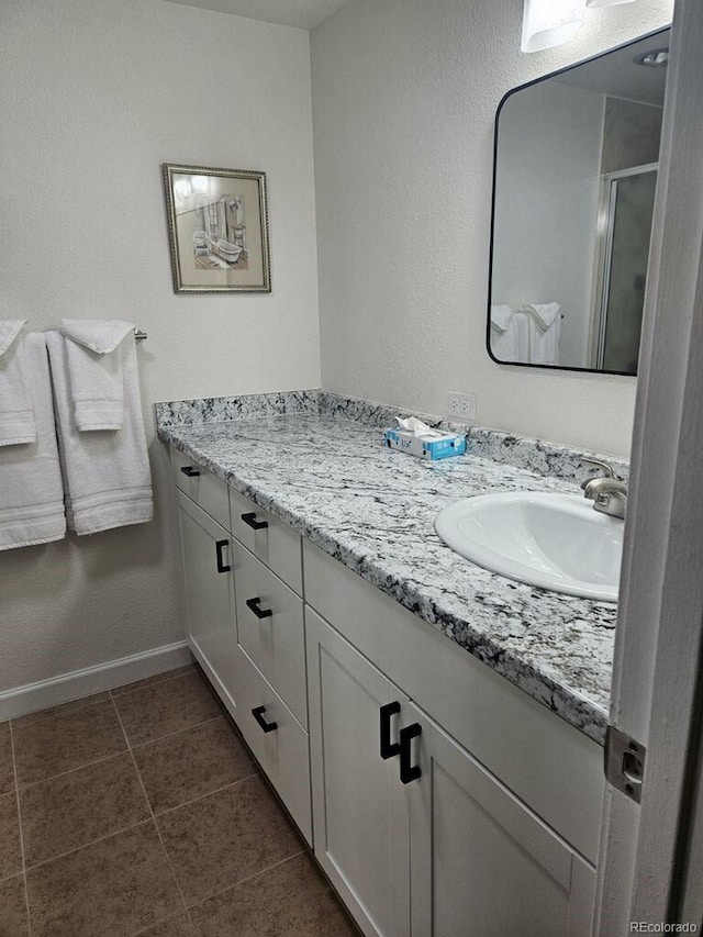 bathroom featuring tile patterned flooring, vanity, and an enclosed shower