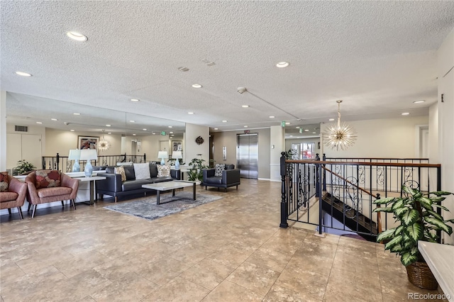 living room with elevator, a textured ceiling, and an inviting chandelier