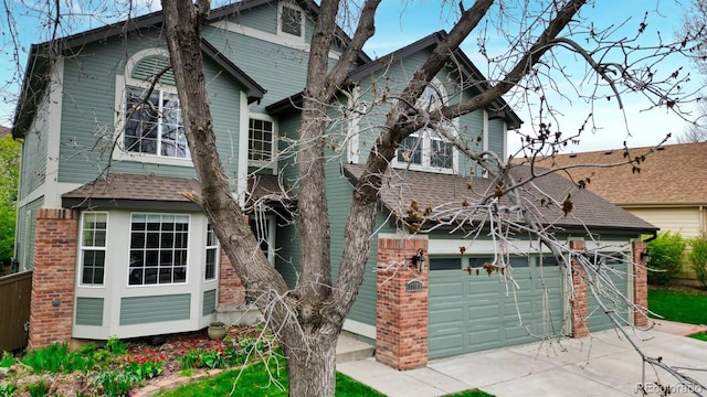 traditional home featuring concrete driveway and brick siding