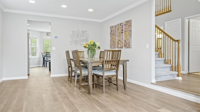 dining space with light wood finished floors, stairway, and baseboards