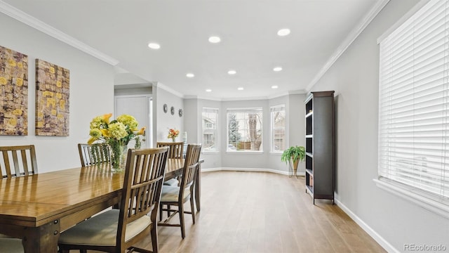 dining room featuring baseboards, ornamental molding, and light wood-type flooring