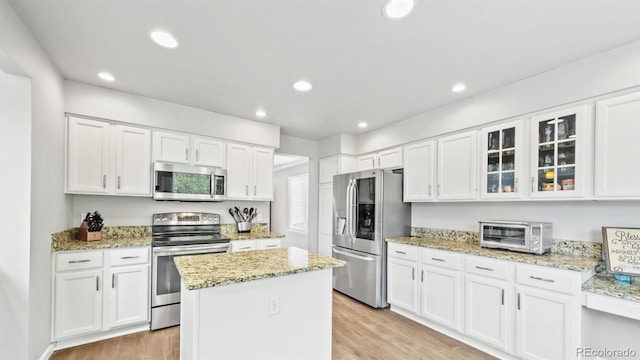 kitchen with white cabinets, appliances with stainless steel finishes, and a toaster