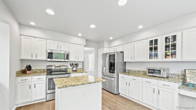 10052 Sage Sparrow Ct, Highlands Ranch, CO 80129 - kitchen with white cabinets, appliances with stainless steel finishes, and a toaster